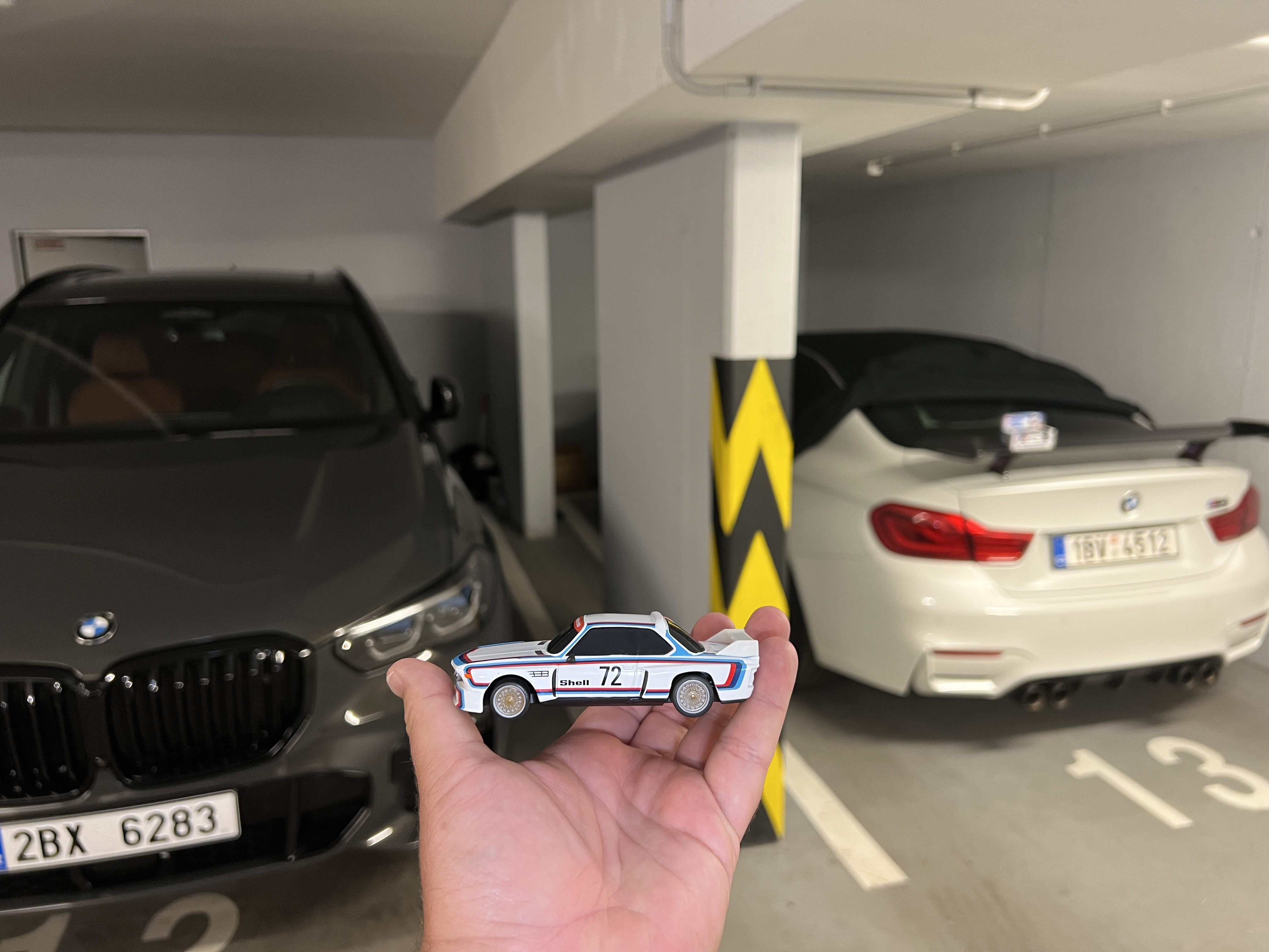 hand holding miniature car in parking garage