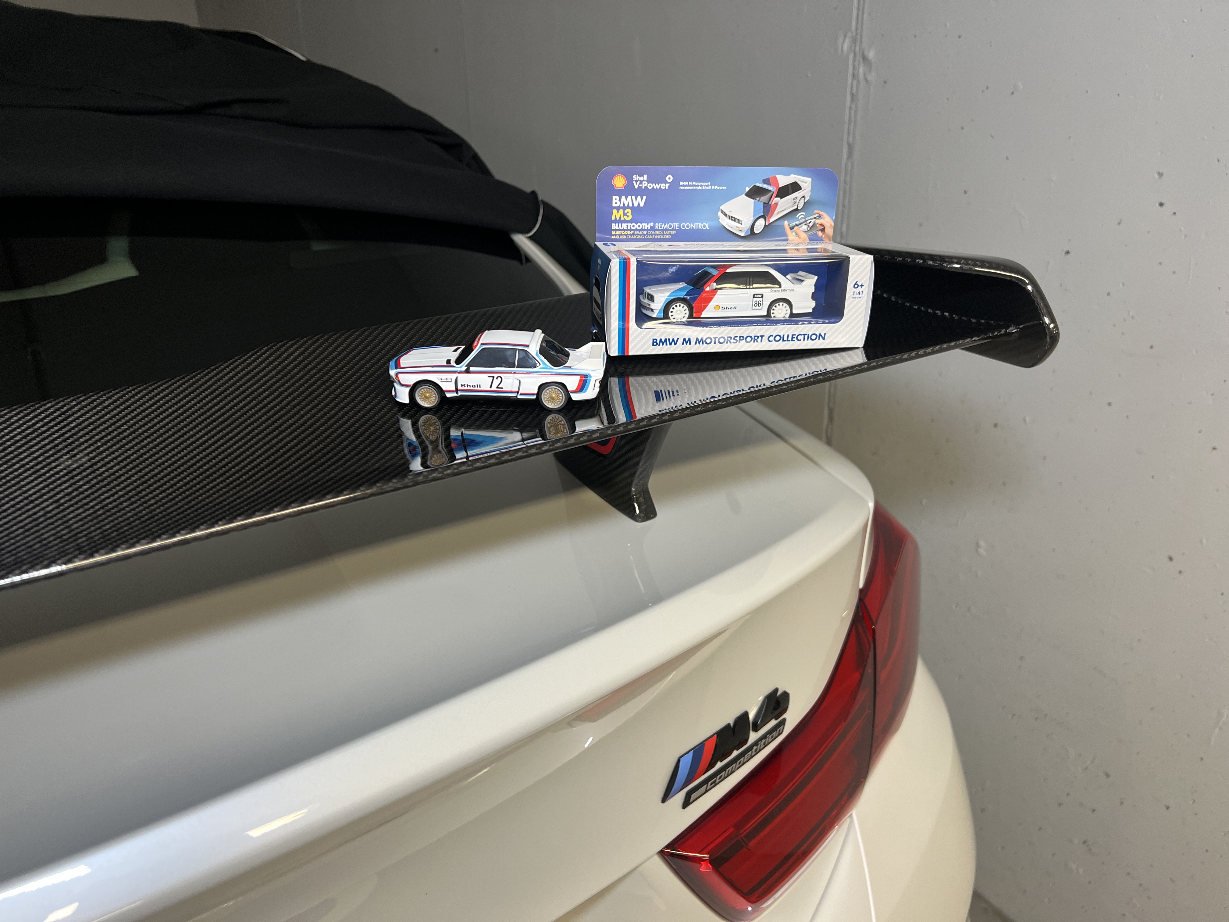 miniature car and box on m4 spoiler