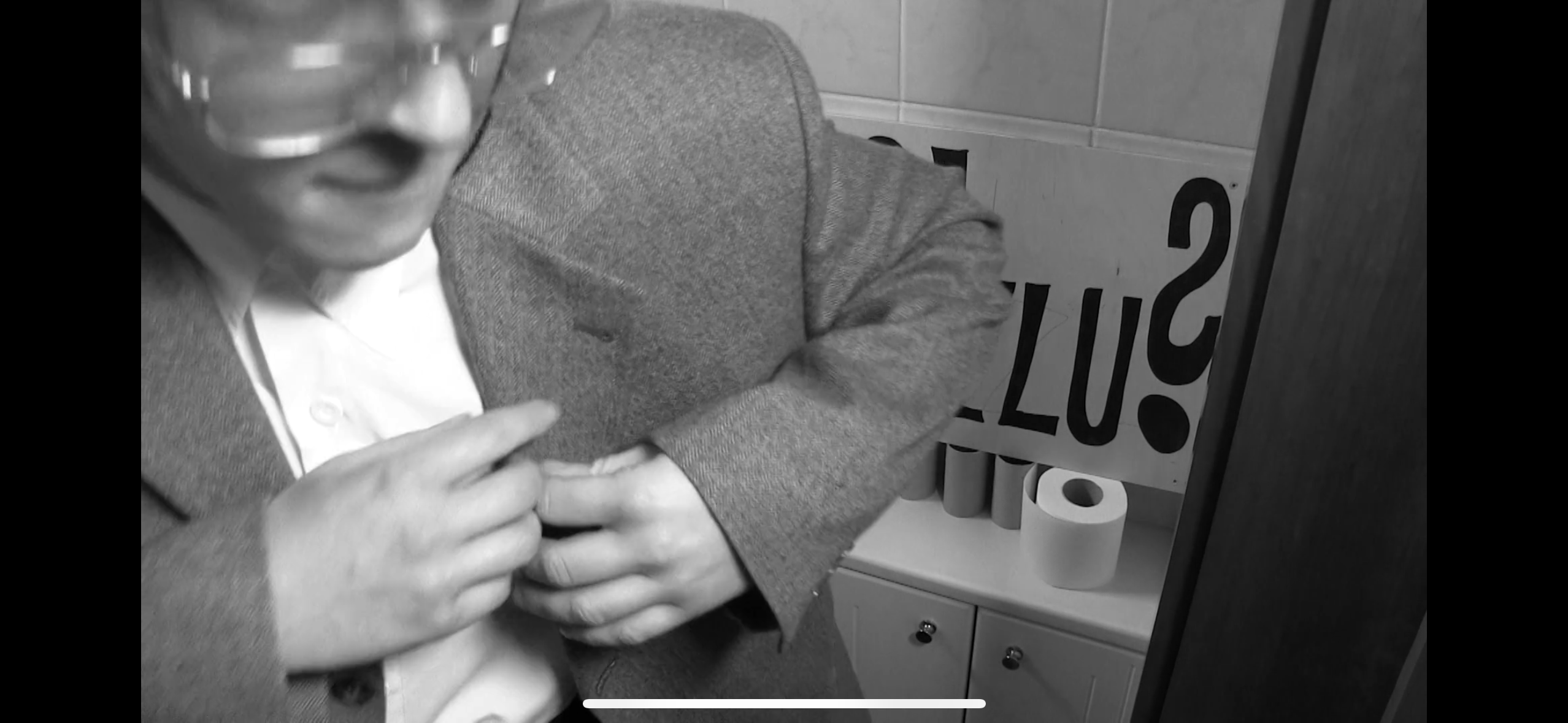 man adjusting suit in bathroom