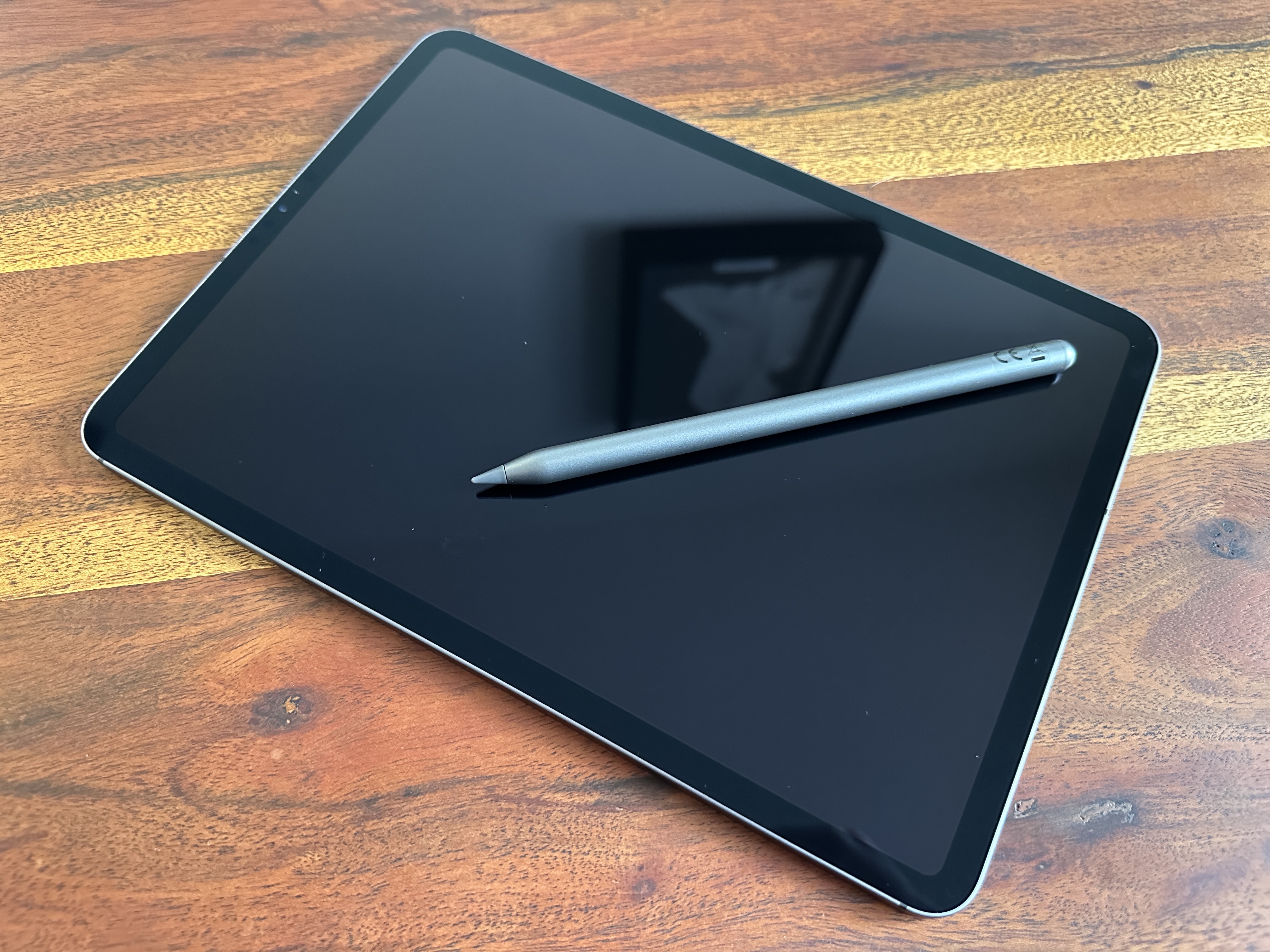 tablet with stylus on wooden table