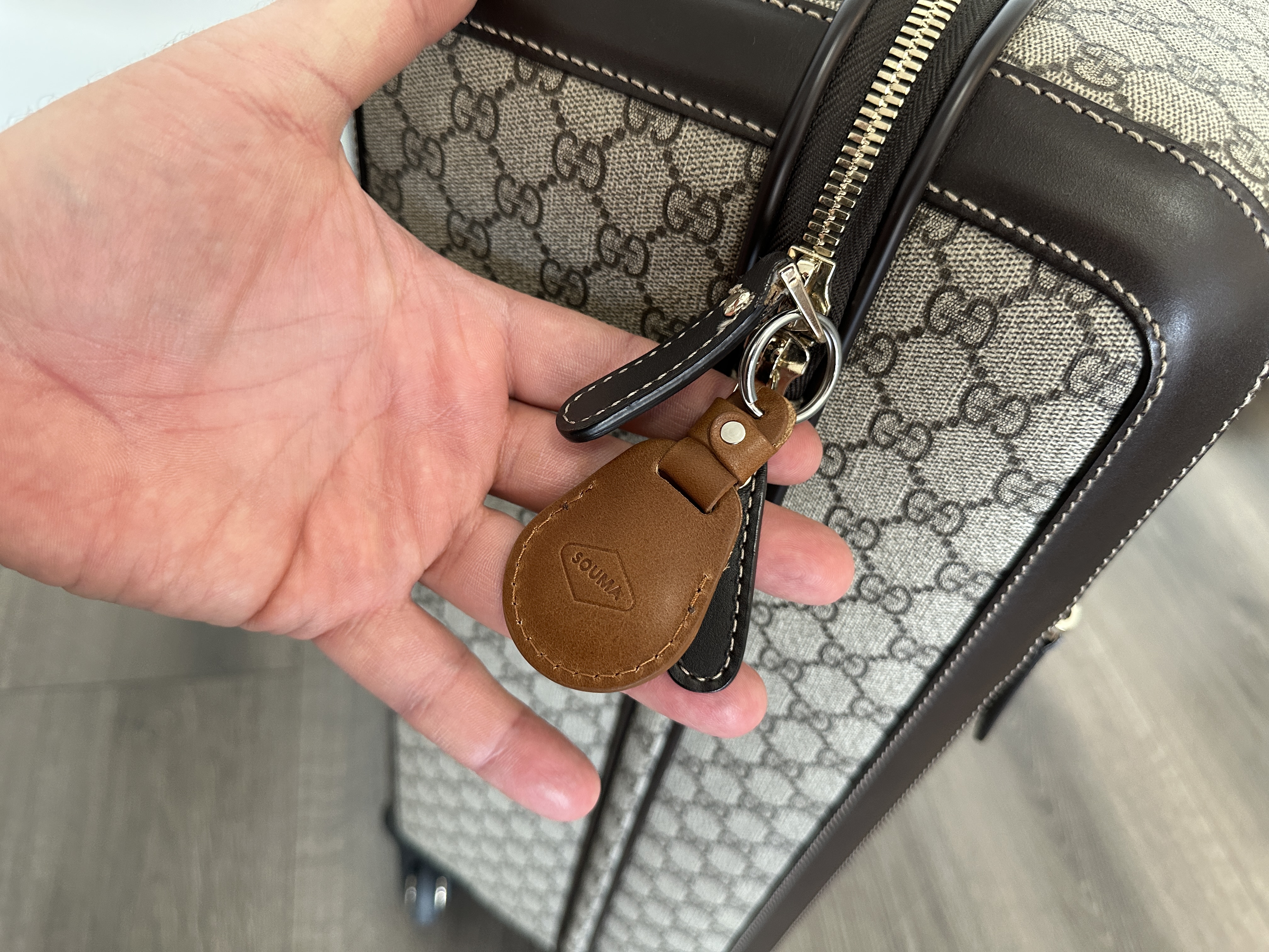 hand holding luggage tracker