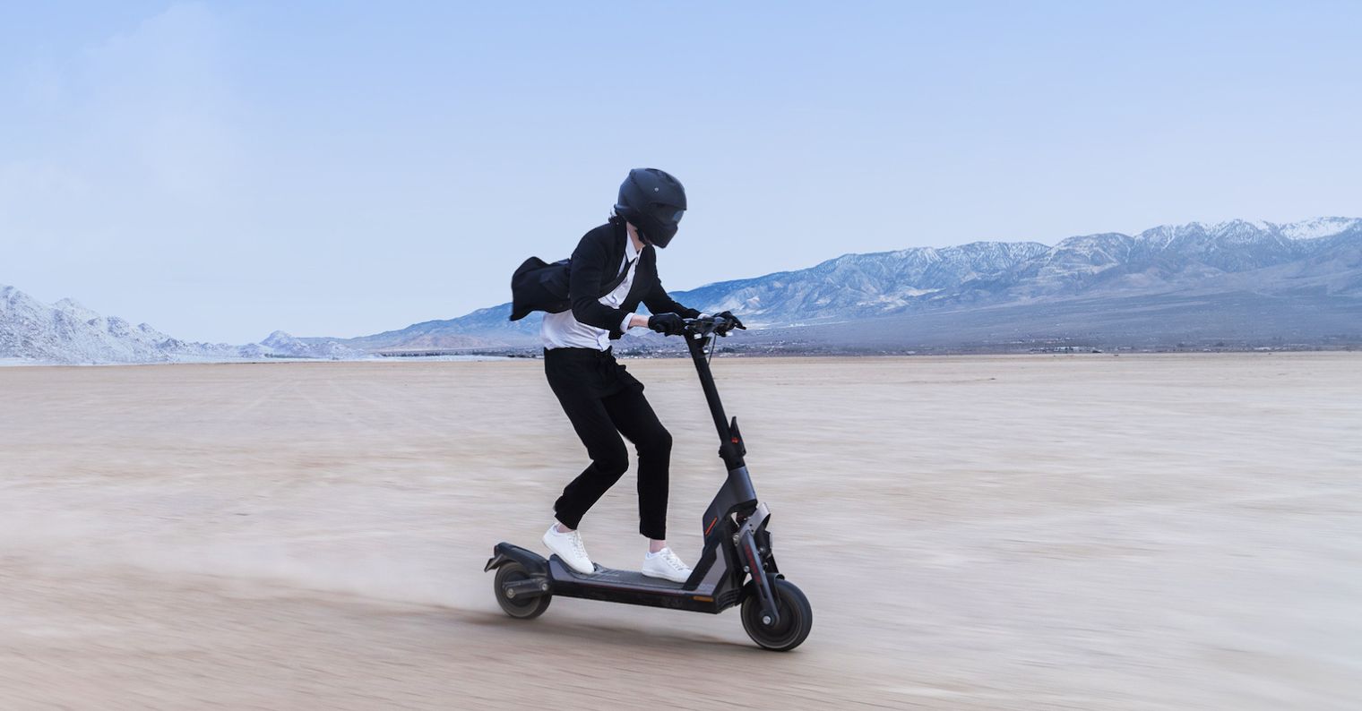 person riding electric scooter in desert