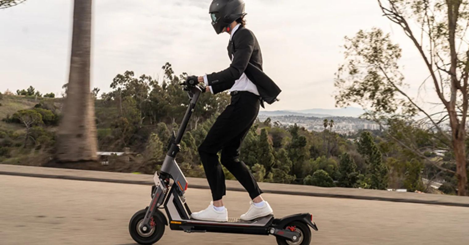 person riding electric scooter on road