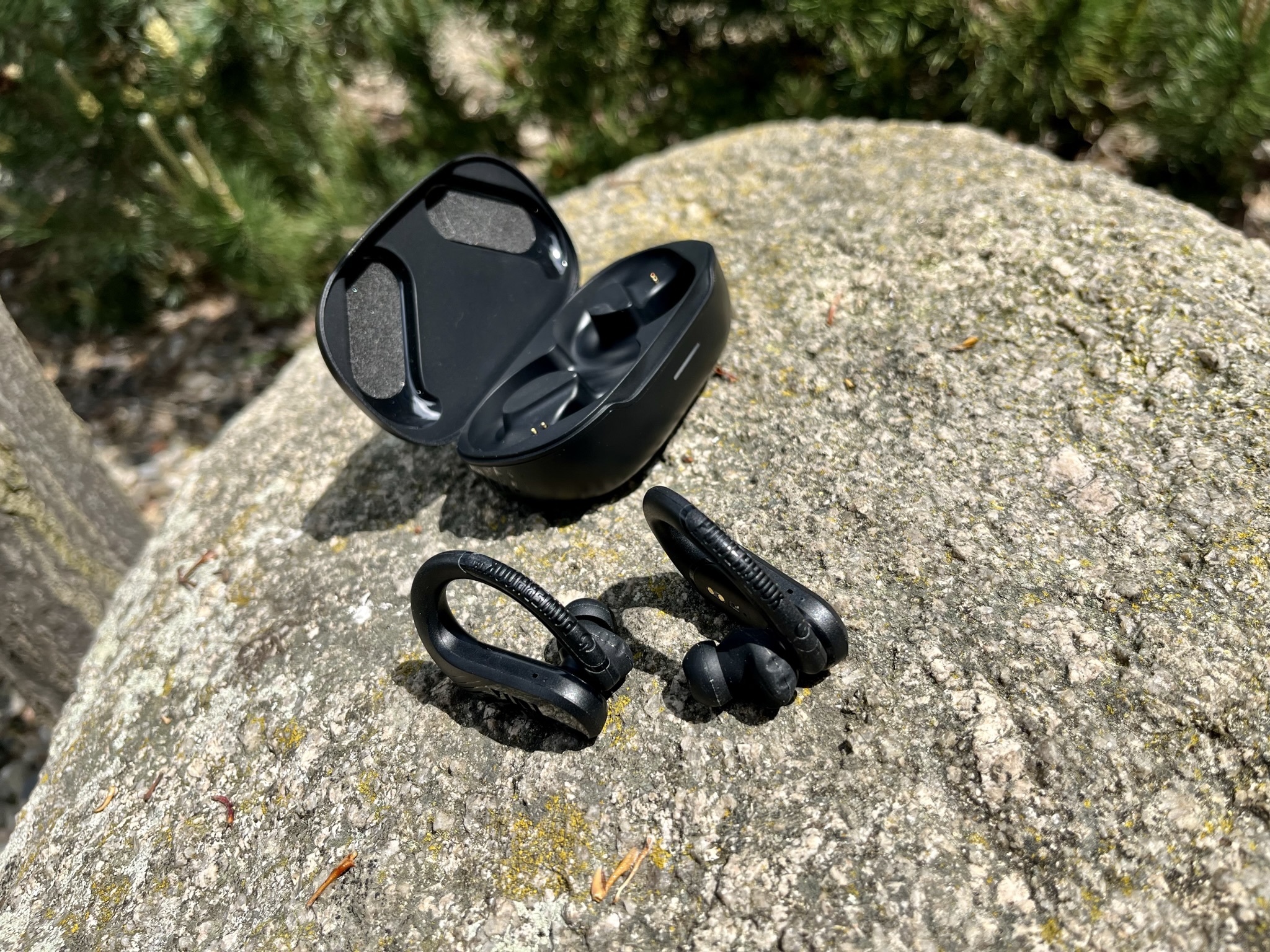 earbuds and case on rock