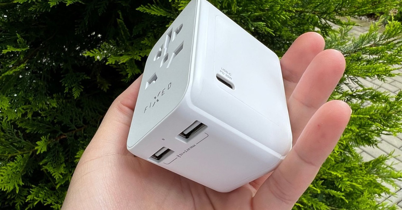 hand holding travel adapter hand holding travel adapter