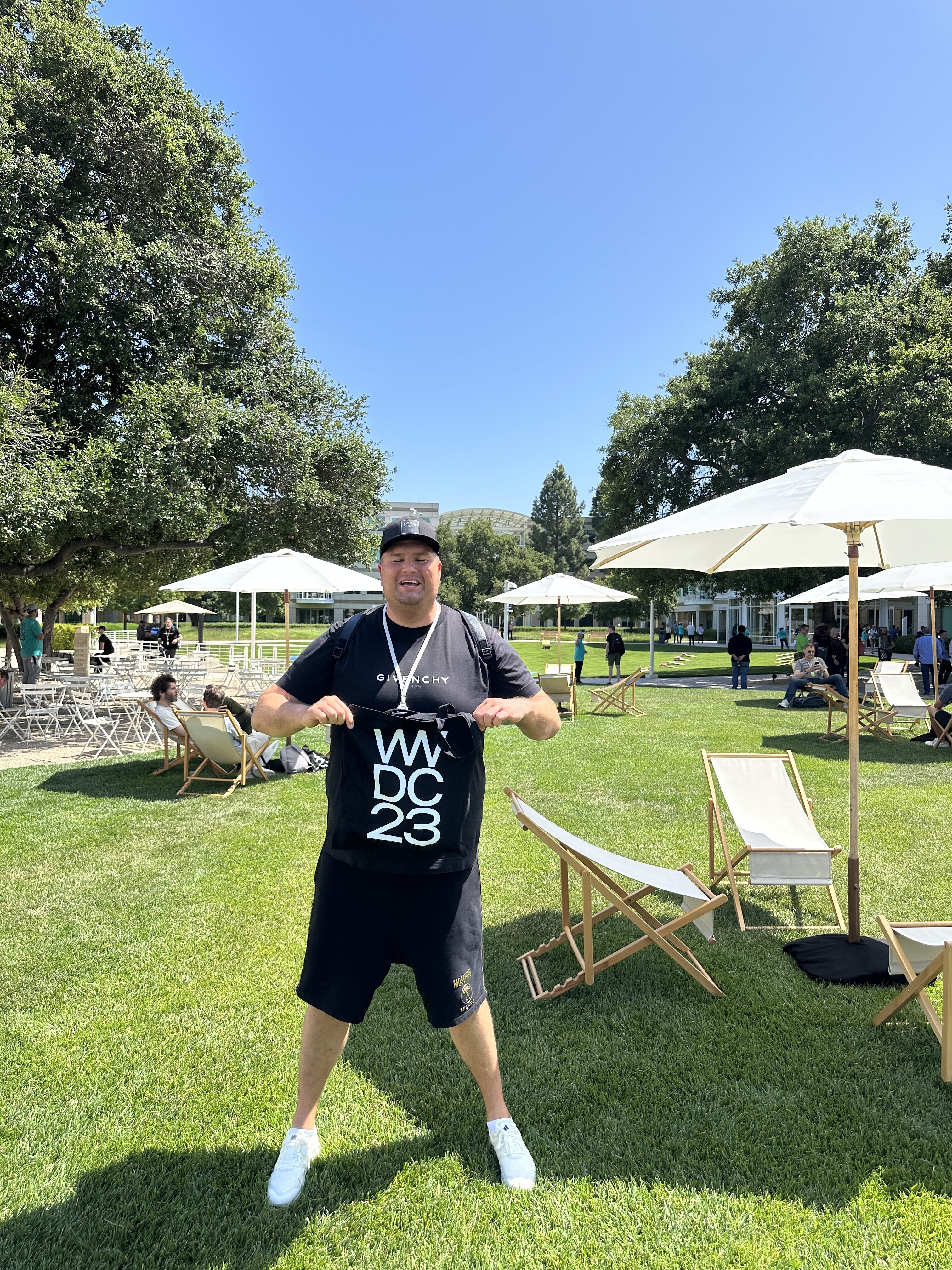 man holding wwdc23 shirt outdoors