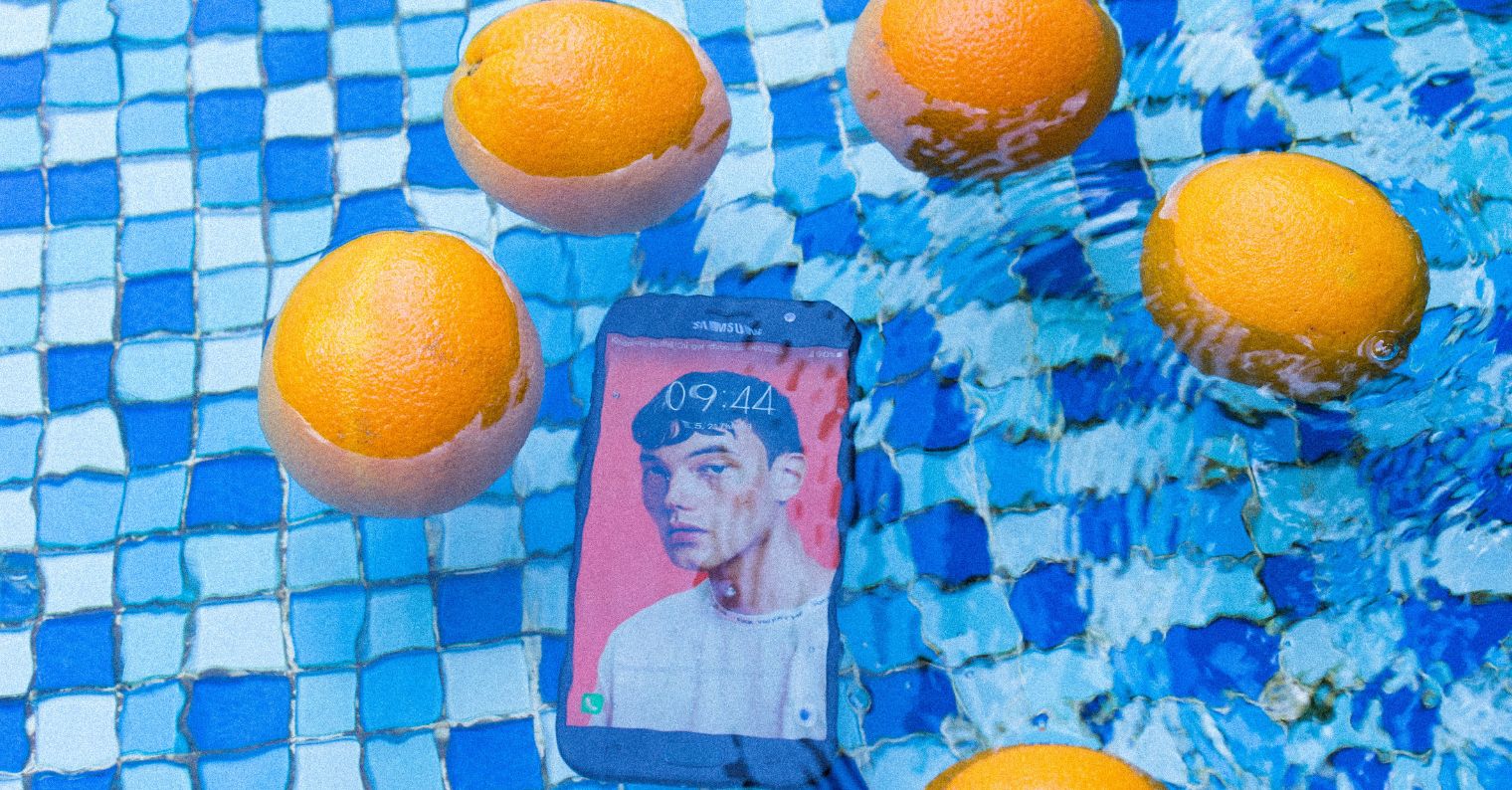 phone in pool with oranges