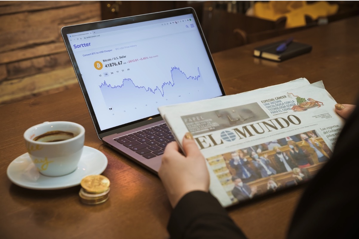 reading newspaper laptop cryptocurrency