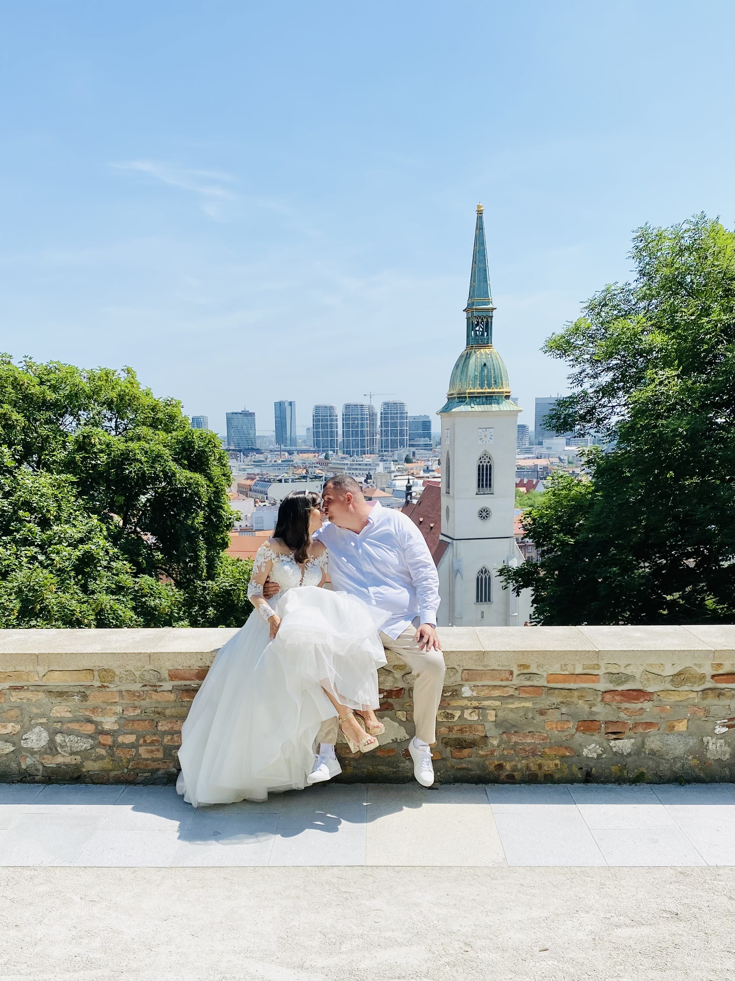 bride and groom kissing with cityscape
