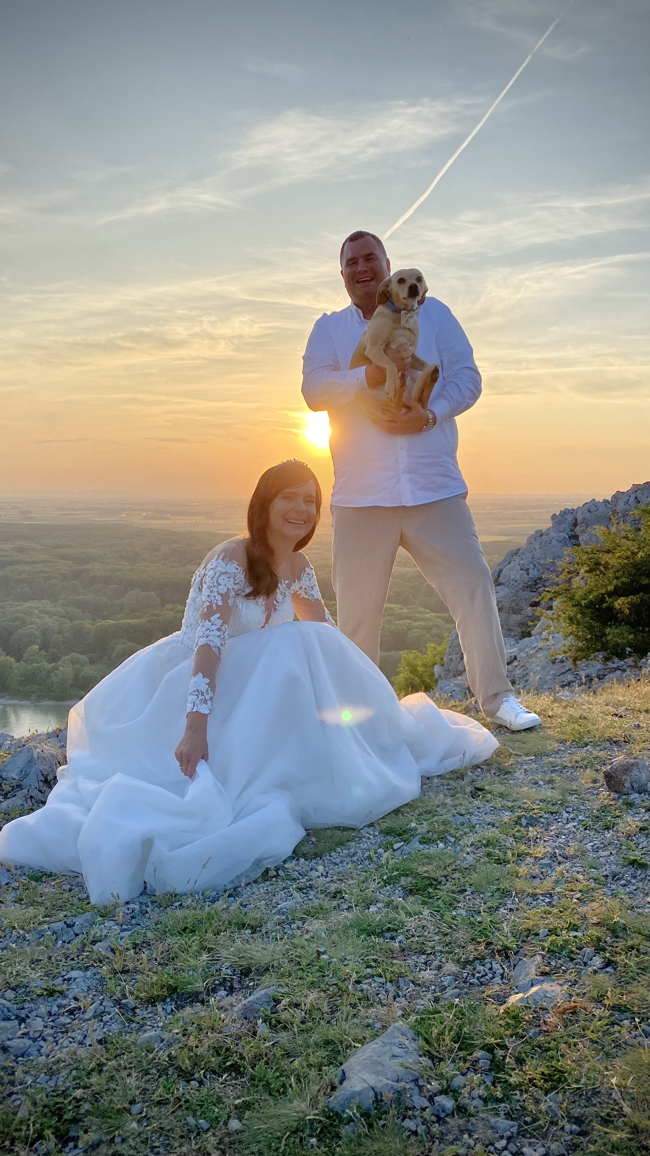 bride and groom with dog at sunset