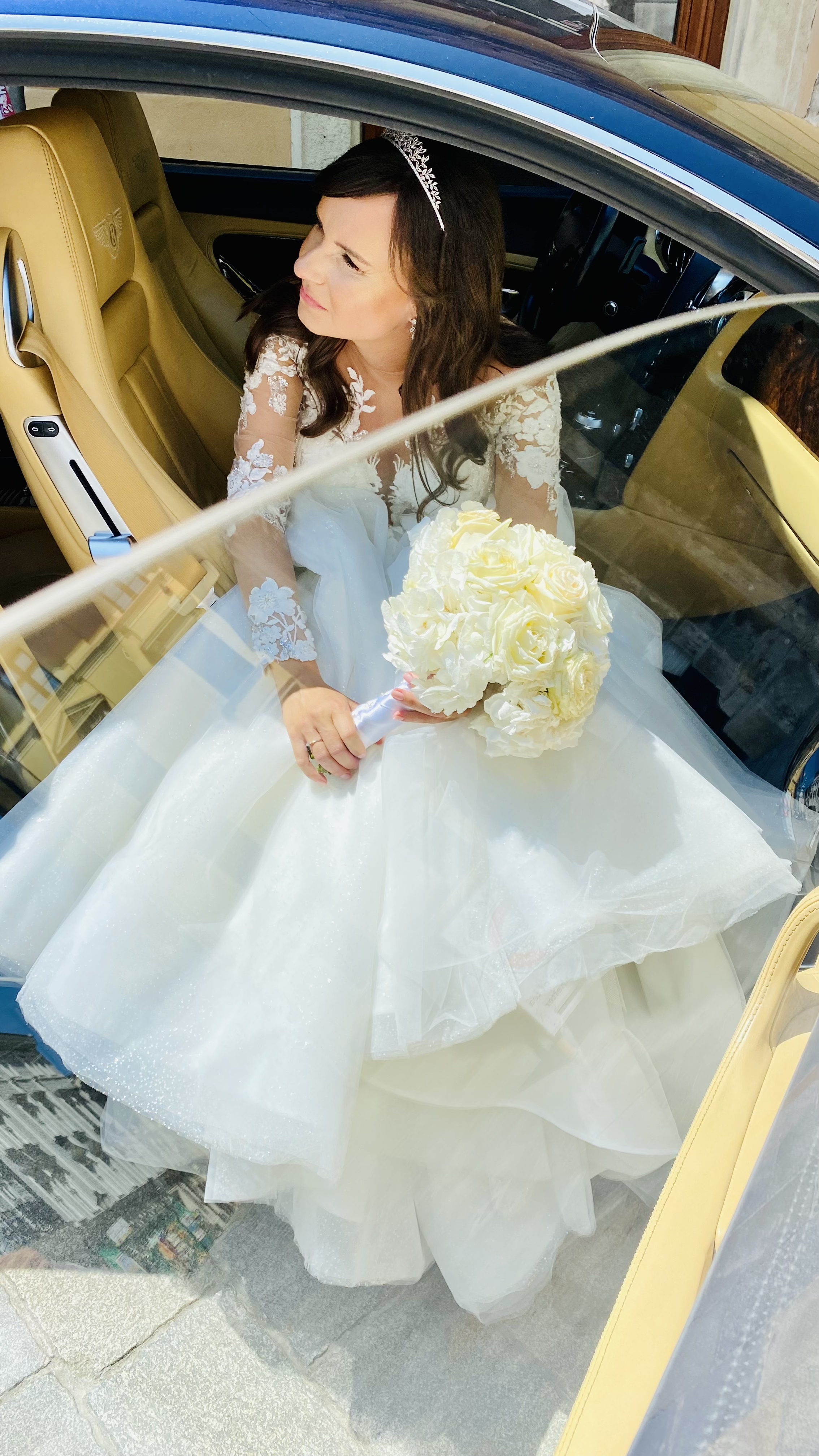 bride in car holding bouquet