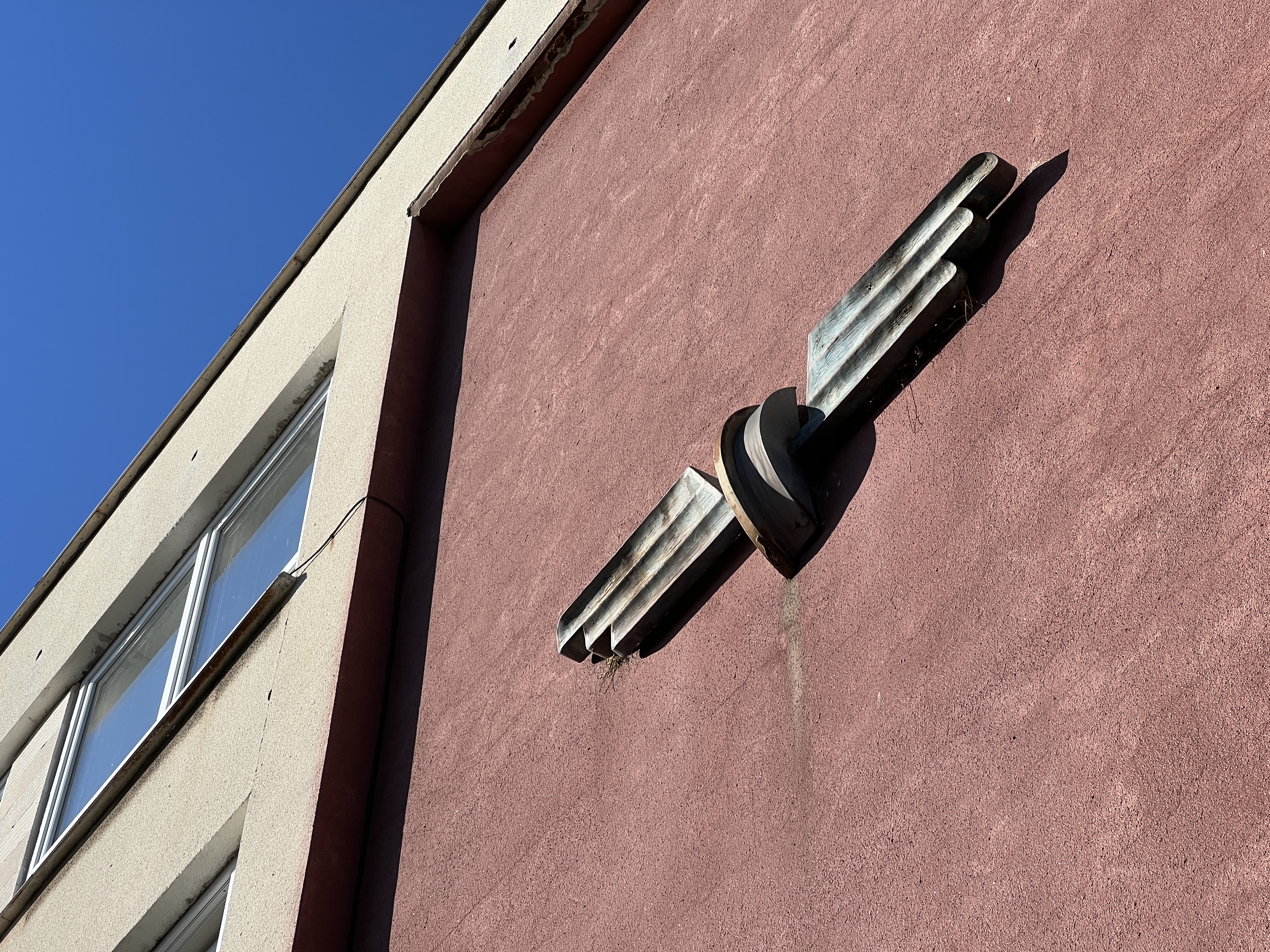 building with wing sculpture