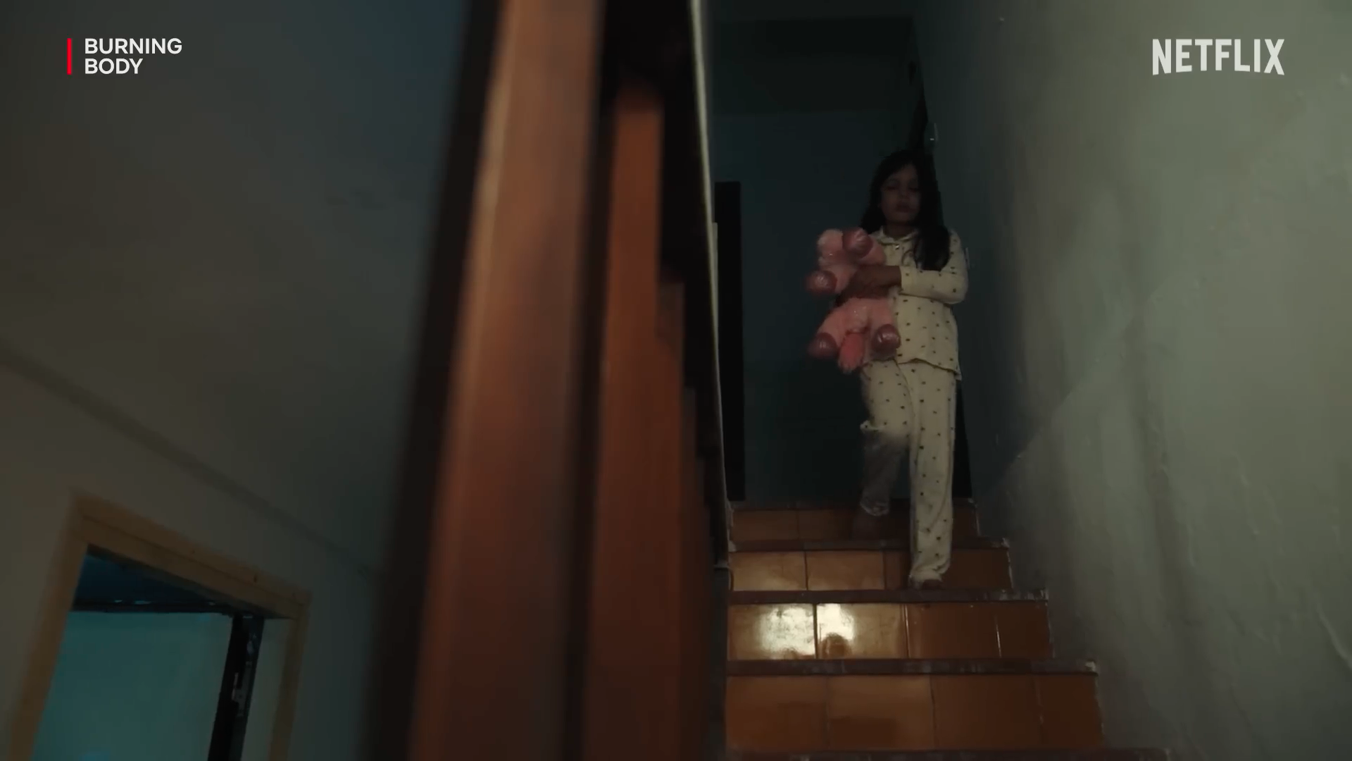 girl holding teddy bear on stairs
