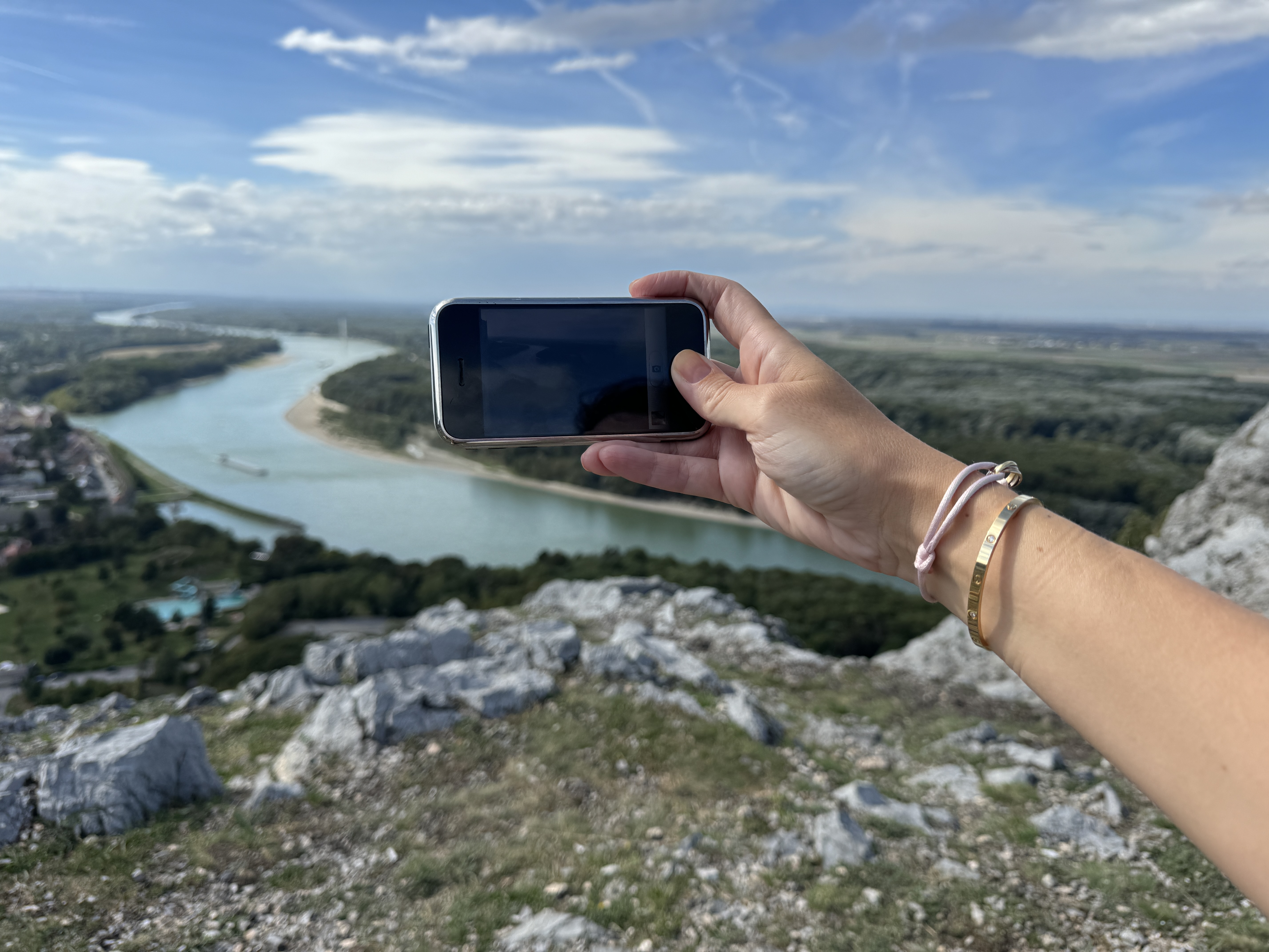 hand holding phone over river view