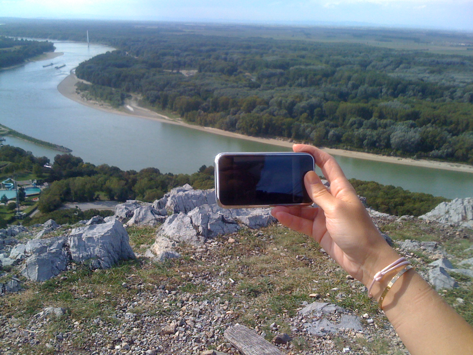 hand holding phone over river