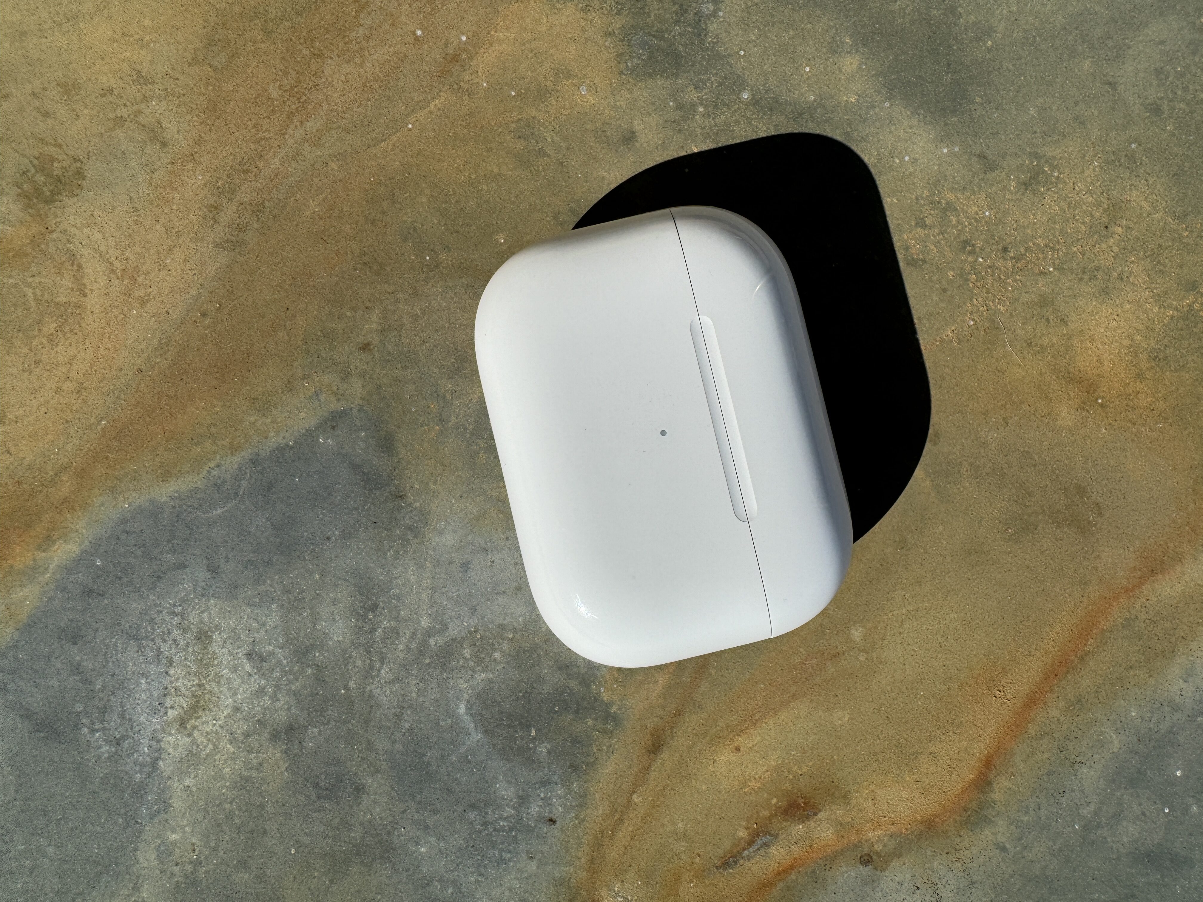wireless earbuds case on stone