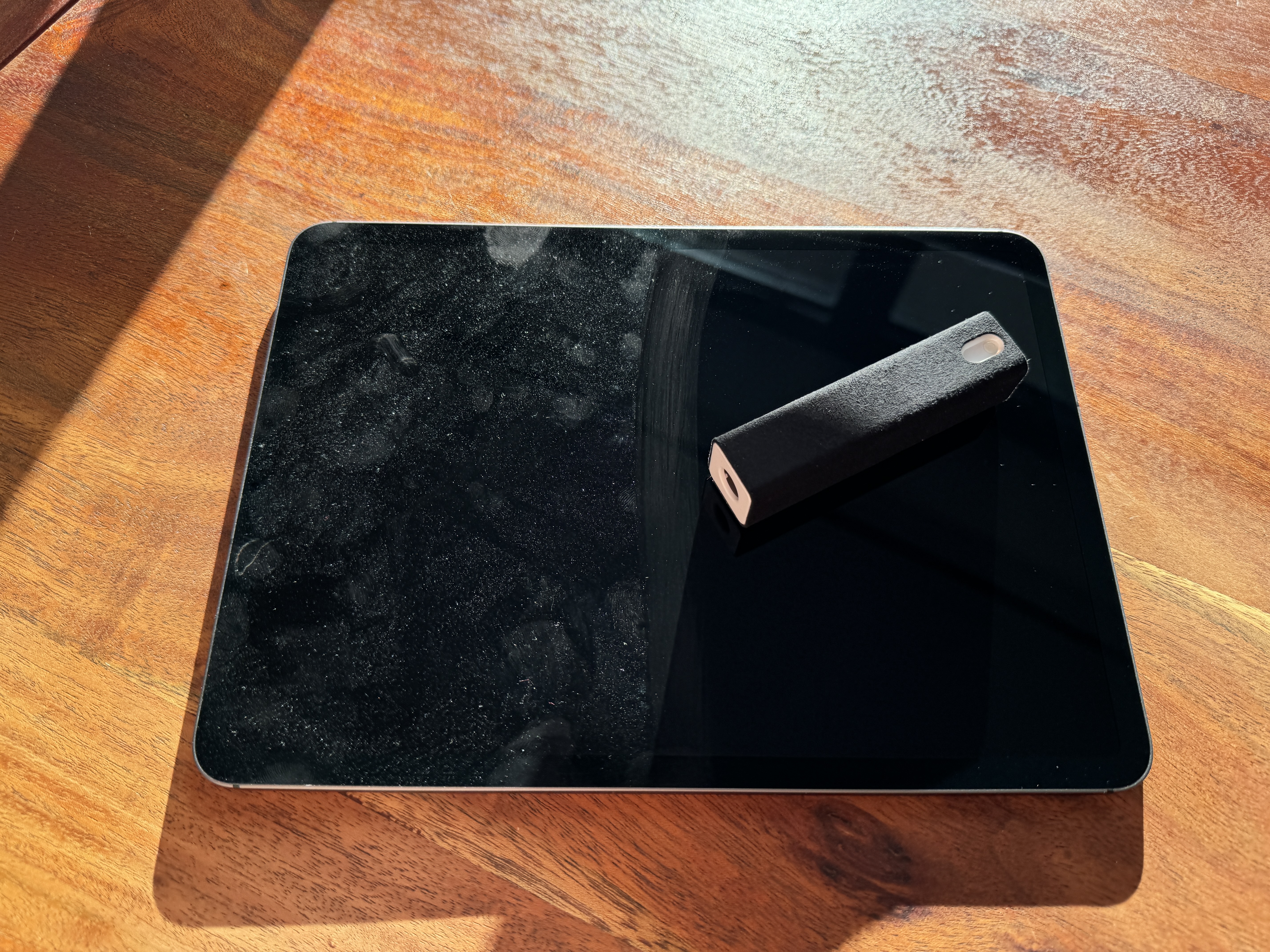 black tablet with device on wooden table