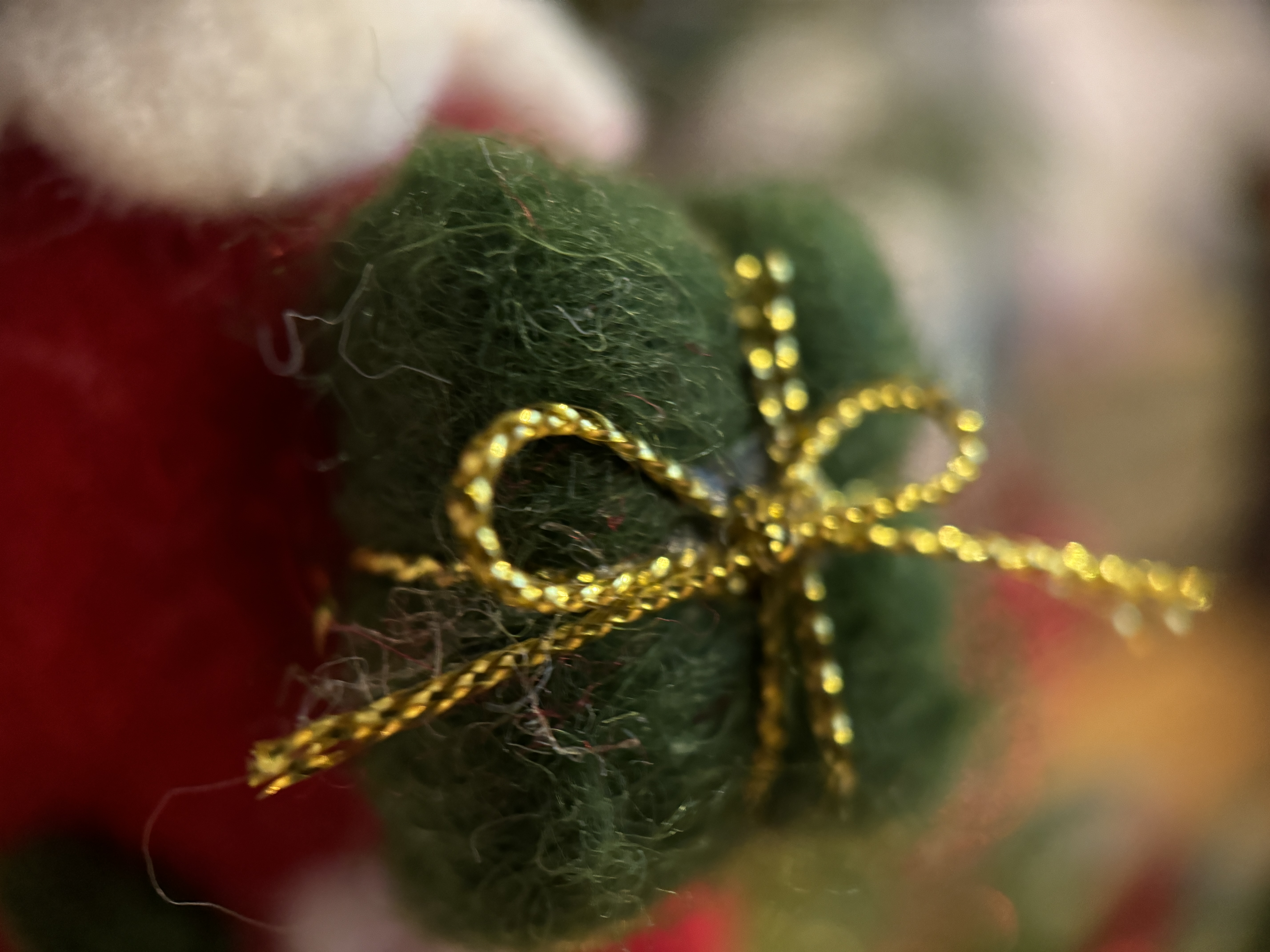 green gift ornament with gold bow