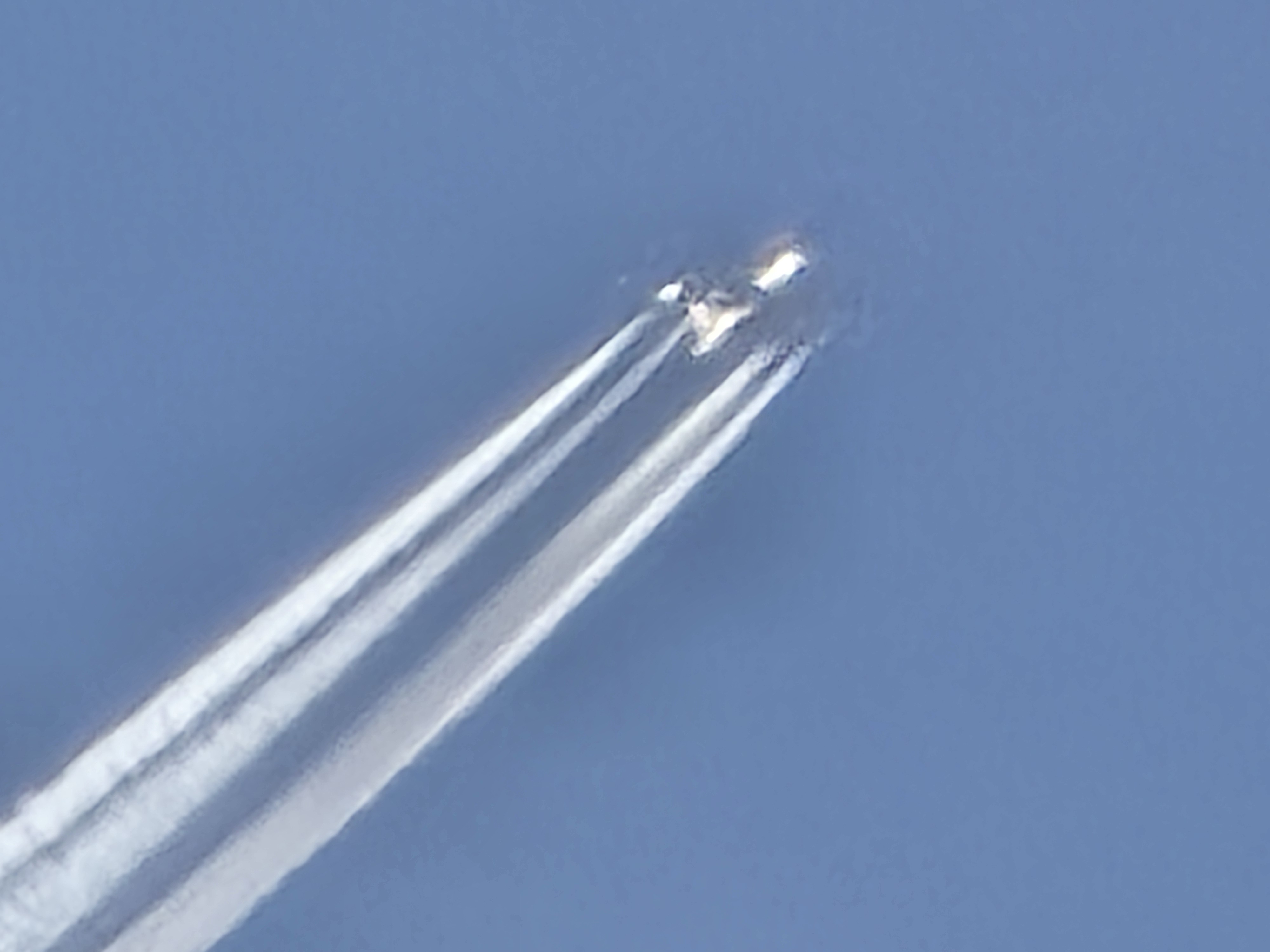 close up of airplane with contrail