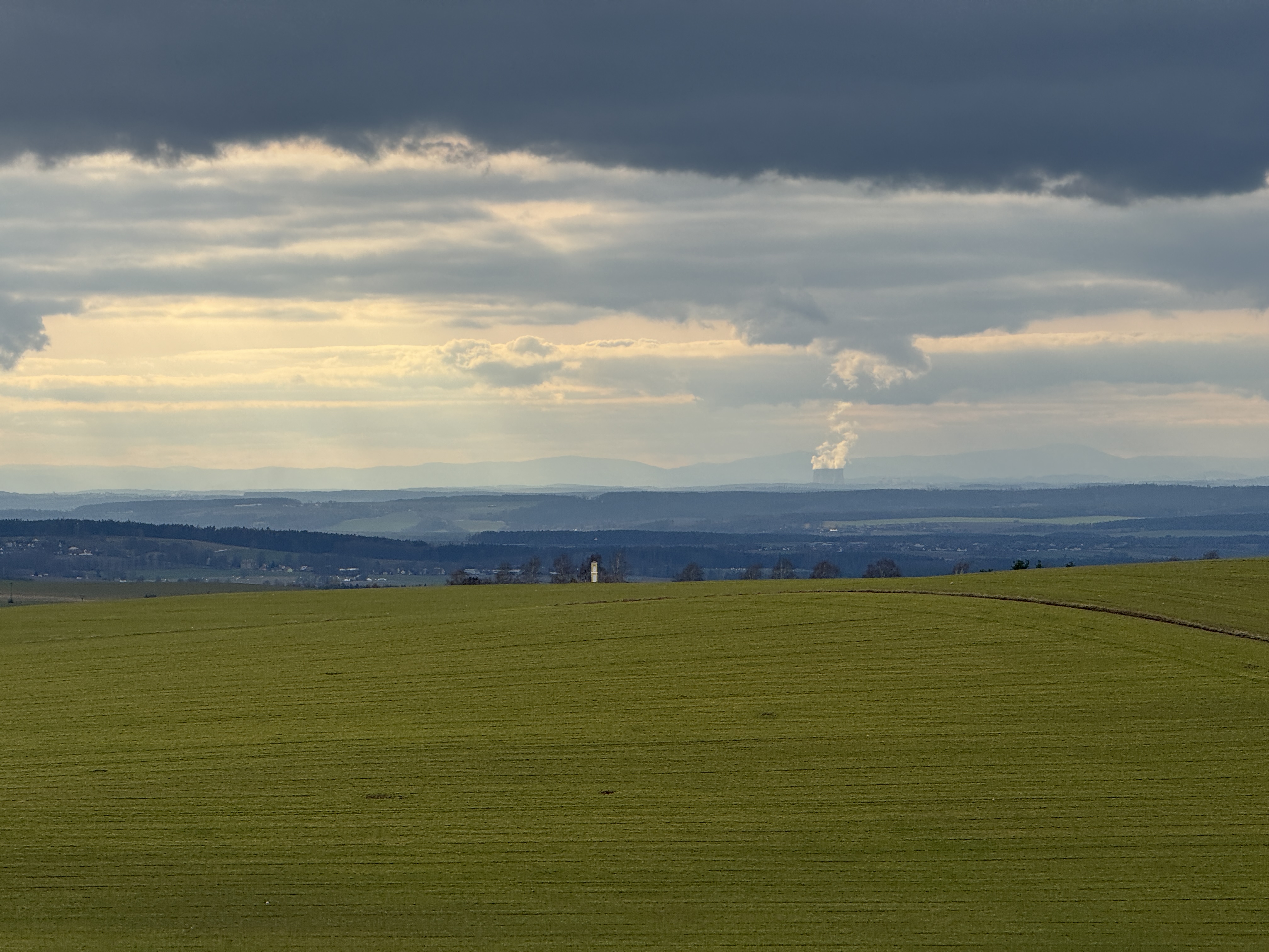 wide field with distant smoke