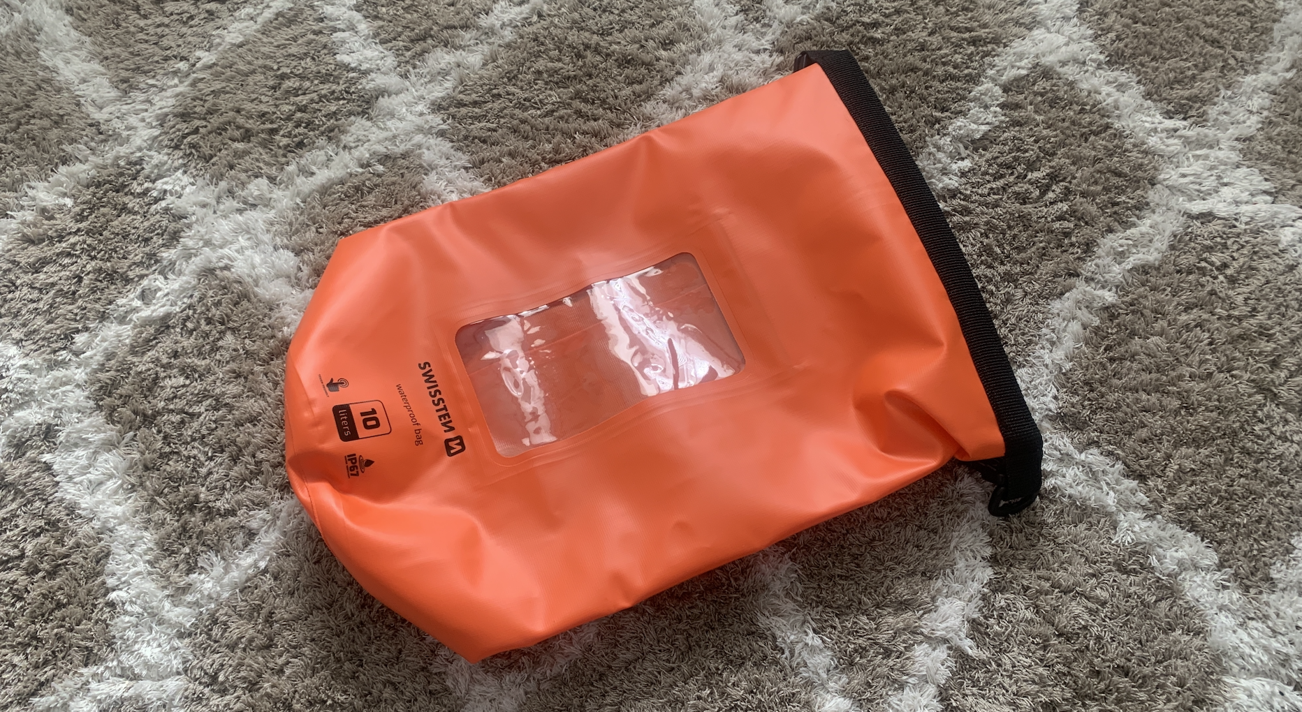 orange dry bag on carpet
