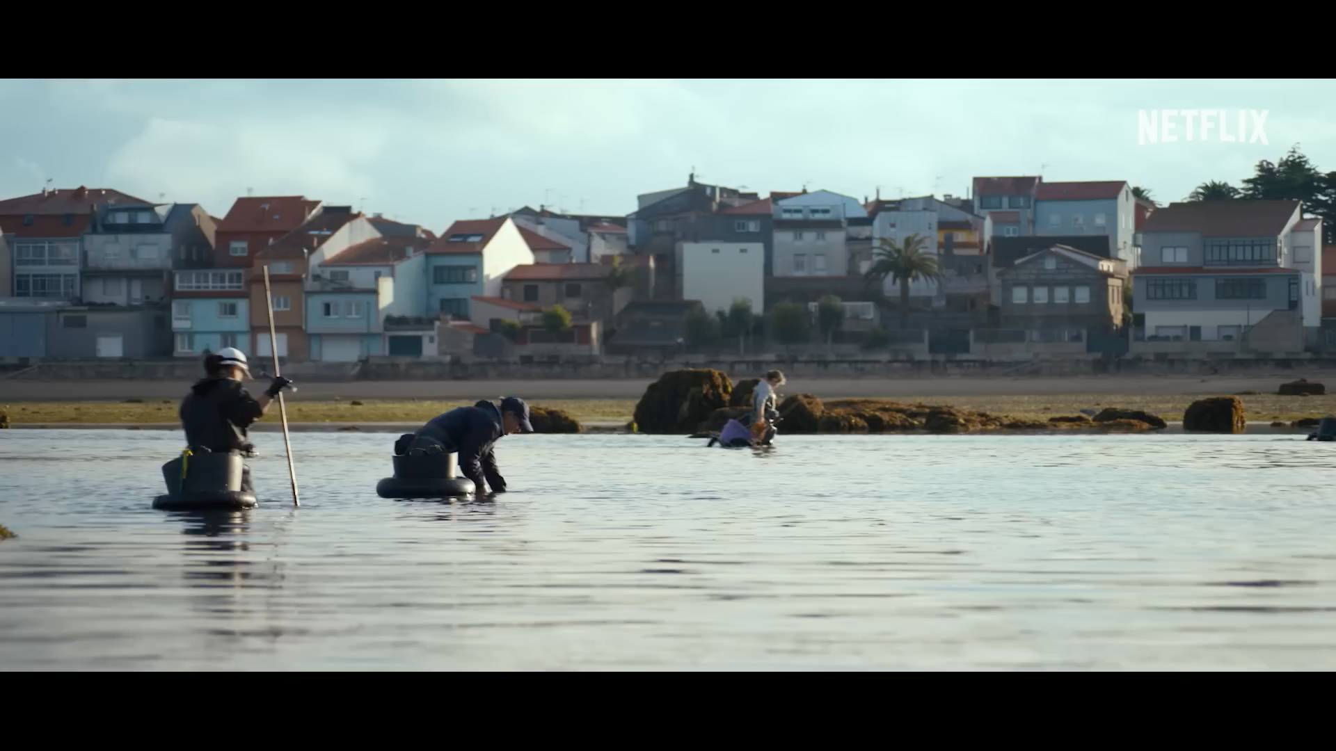 people fishing near coastal town