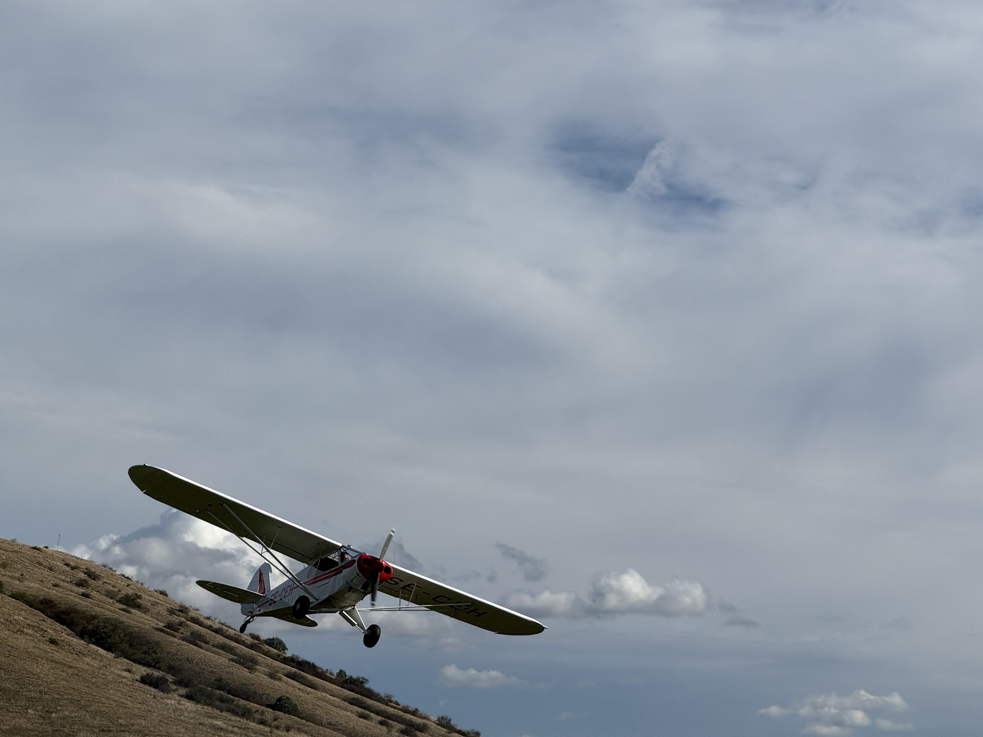 airplane flying over hill