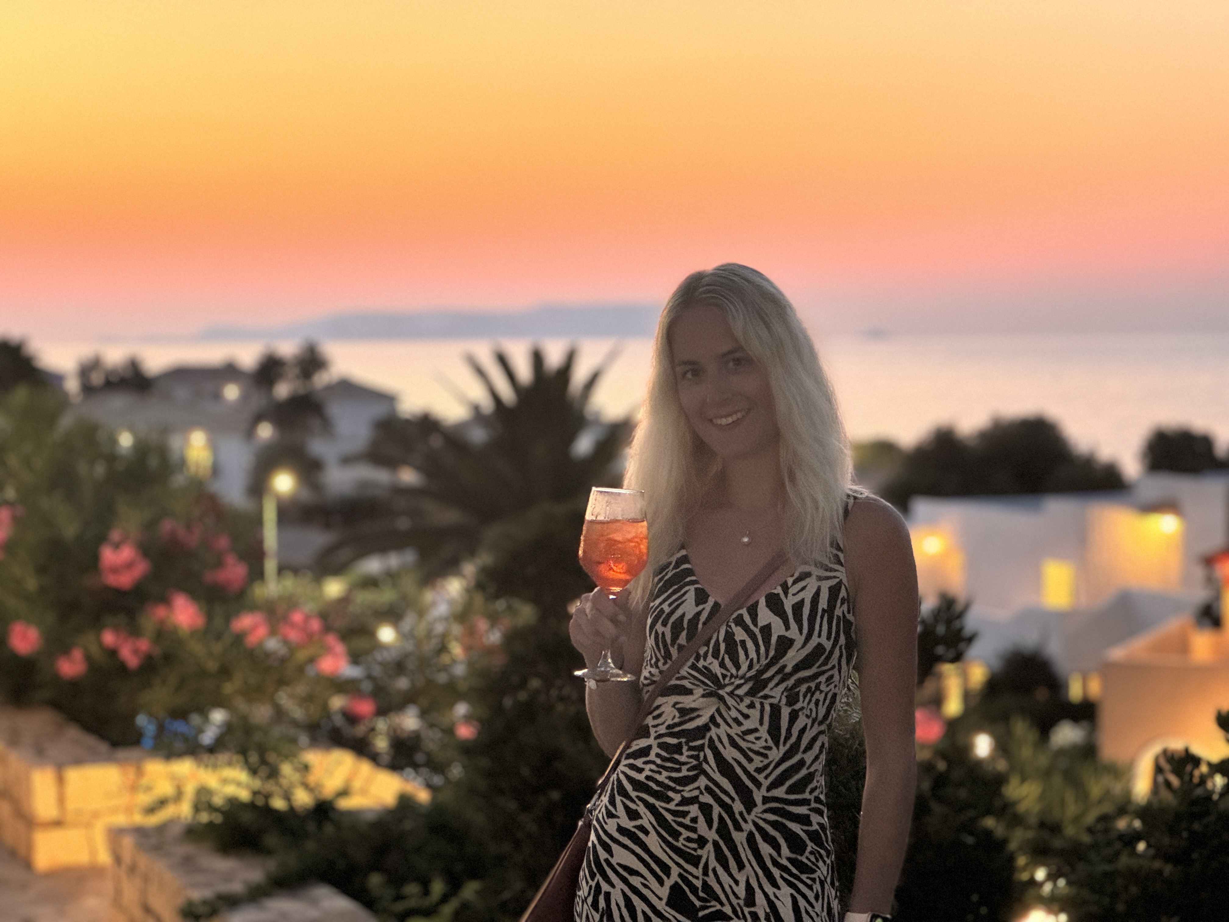 person holding drink at sunset