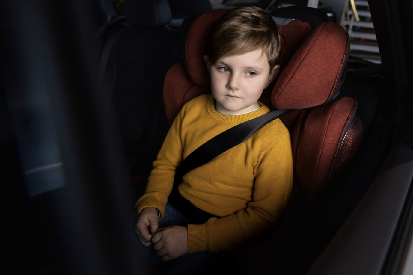 child in car seat wearing yellow