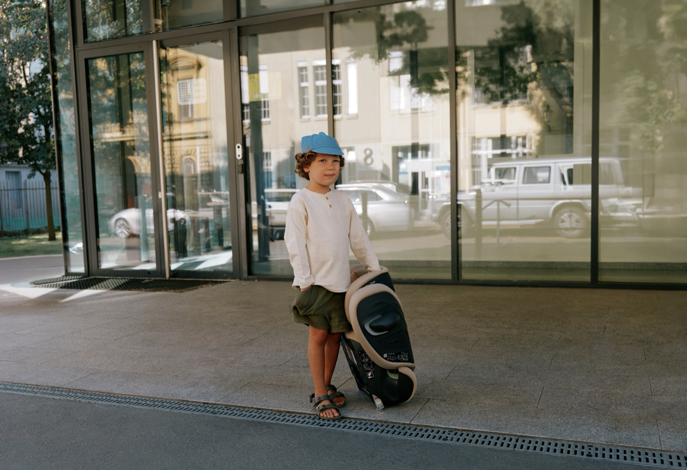 child with suitcase outside building